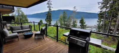 a screened in porch with a view of a lake at Halibut Hideaway in Port Renfrew