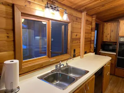 a kitchen with a sink and a window in a cabin at April Point Harbour House in Quathiaski Cove