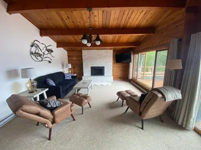 a living room with a couch and chairs and a fireplace at April Point Harbour House in Quathiaski Cove