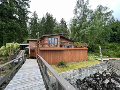 a house with a wooden walkway leading to it at April Point Harbour House in Quathiaski Cove