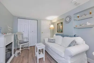 a living room with a white couch and a fireplace at Quaint 1 bedroom lower suite in Victoria, BC in Victoria
