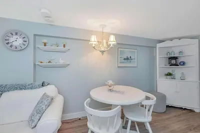 a living room with a white table and a chandelier at Quaint 1 bedroom lower suite in Victoria, BC in Victoria