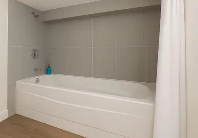 a white bath tub in a bathroom with a shower curtain at Quaint 1 bedroom lower suite in Victoria, BC in Victoria