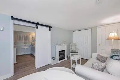 a living room with a white couch and a fireplace at Quaint 1 bedroom lower suite in Victoria, BC in Victoria