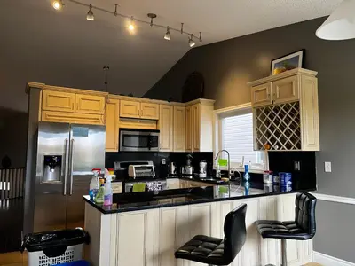 a kitchen with wooden cabinets and a black counter top at citadle hill house! in Calgary
