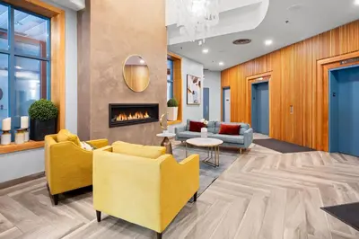 a lobby with yellow chairs and a fireplace at Alpenglow Lodge Large Studio by MVA in Whistler