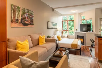 a living room with a couch and a bed at Alpenglow Lodge Large Studio by MVA in Whistler