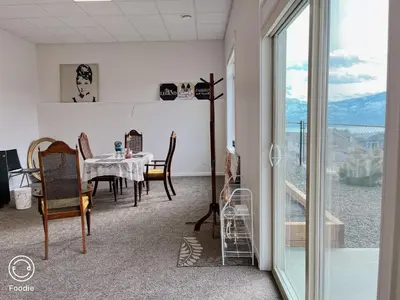 a dining room with a table and chairs and a window at Peaceful and Spacious Lake View in West Kelowna
