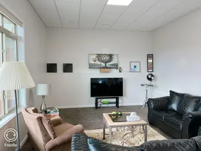 a living room with two couches and a tv at Peaceful and Spacious Lake View in West Kelowna
