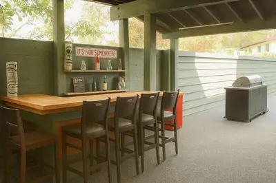 a patio with a bar with chairs and a television at Hidden Oasis in Victoria, BC in Victoria