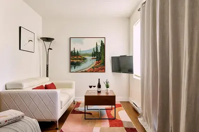 a living room with a white couch and a tv at Liahona Guest House in Ucluelet