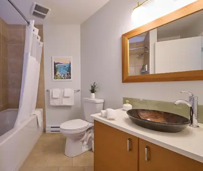 a bathroom with a sink and a toilet and a tub at Liahona Guest House in Ucluelet