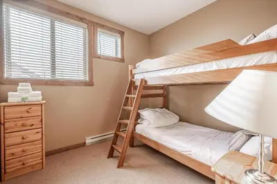 a bedroom with two bunk beds and a lamp at Trapper's Lodge - 4 Bd w Great View, Private Hot Tub in Big White