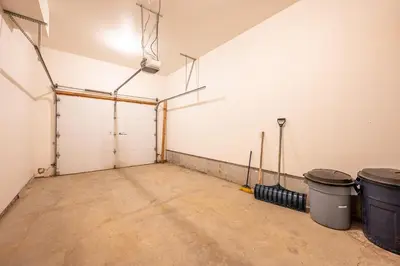 an empty garage with two trash cans at Trapper's Lodge - 4 Bd w Great View, Private Hot Tub in Big White