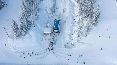 a ski lift in the snow with people on it at Trapper's Lodge - 4 Bd w Great View, Private Hot Tub in Big White
