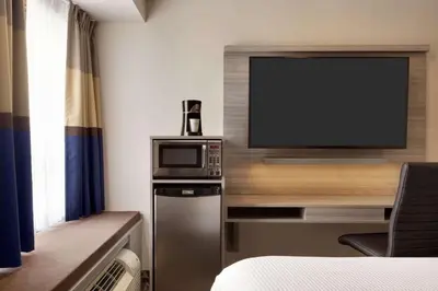 a room with a flat screen tv and a small refrigerator at Microtel Inn & Suites by Wyndham Lloydminster in Lloydminster