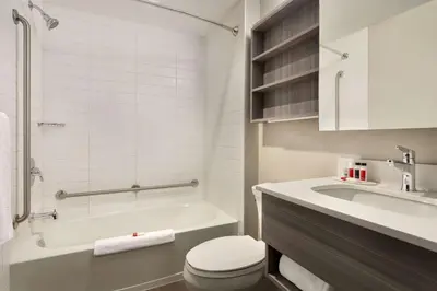 a bathroom with a tub and a toilet and a sink at Microtel Inn & Suites by Wyndham Lloydminster in Lloydminster