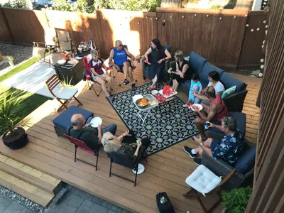 a group of people sitting in chairs on a patio at walk distance to kits beach 2bedrooms only for you in Vancouver