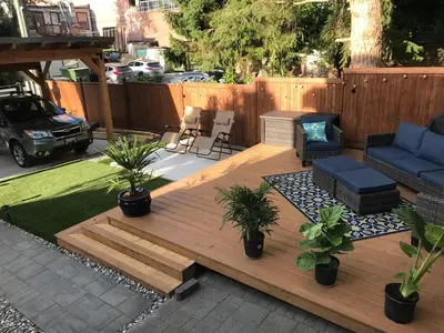 a backyard with a wooden deck with plants and a blue couch at walk distance to kits beach 2bedrooms only for you in Vancouver
