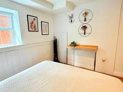 a bedroom with a bed and some pictures on the wall at walk distance to kits beach 2bedrooms only for you in Vancouver