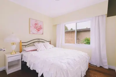 a white bedroom with a bed and a window at LOVELY 3 bedroom PORT MOODY spacious home 6 people free parking in Port Moody