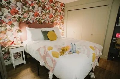 a bedroom with a bed with a floral wall at The Garden Room at Waddington Flats in Victoria