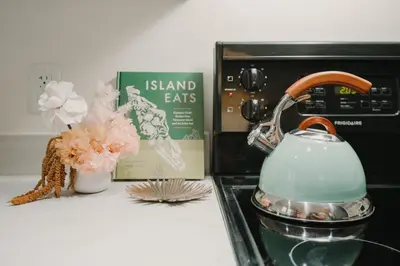 a tea kettle on a counter next to a microwave at The Garden Room at Waddington Flats in Victoria