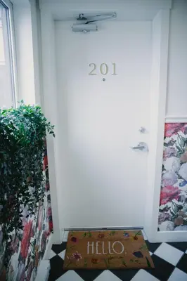 a welcome mat in front of a door with a hello sign at The Garden Room at Waddington Flats in Victoria