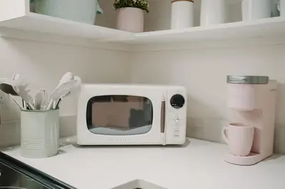 a white microwave sitting on a kitchen counter at The Garden Room at Waddington Flats in Victoria