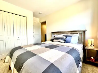 a bedroom with a large bed with blue and white at Perfect base Invermere 3bd townhouse mt views with garage in Invermere