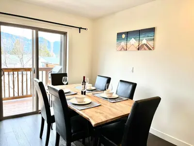 a dining room with a wooden table and chairs at Perfect base Invermere 3bd townhouse mt views with garage in Invermere