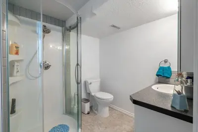 a bathroom with a shower and a toilet and a sink at Bahama Breeze I Hot Tub I Pool I 5 Bedroom in Drumheller