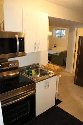 a kitchen with a sink and a microwave at Guest Suite in Calgary in Calgary