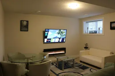 a living room with a couch and a table and a tv at Guest Suite in Calgary in Calgary