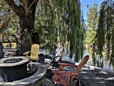a group of chairs sitting in front of a lake at Waterfront Oasis with Pool, Hot Tub & Pet Friendly in Kelowna