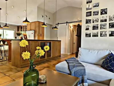 a living room with a vase with yellow flowers on a table at Waterfront Oasis with Pool, Hot Tub & Pet Friendly in Kelowna