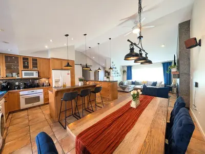a kitchen and living room with a table and chairs at Waterfront Oasis with Pool, Hot Tub & Pet Friendly in Kelowna