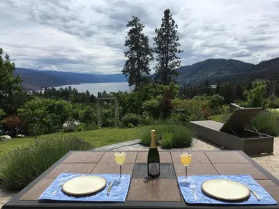 a table with a bottle of wine and two glasses at Lakeview Gardens B&B in Peachland