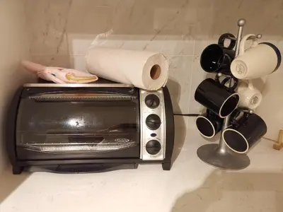 a toaster oven with a roll of paper towels on top at JESI'S NEW HOUSE, Self Enter 2BR, Whole Suite, Close to White Rock Beach & US Border in Surrey