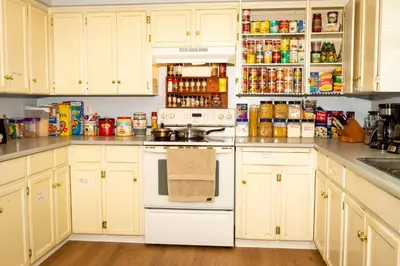 a kitchen with white cabinets and a stove top oven at B&B In Fraser Valley in Abbotsford