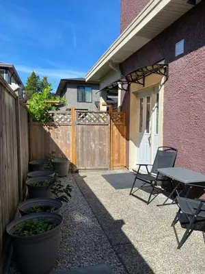 a patio with a table and chairs and a fence at Private cozy suite near Dyke and Fisherman's Wharf in Richmond