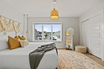 a bedroom with a large white bed and a window at The Promenade I Patio and BBQ I Fire pit I Sleep 9 in Sylvan Lake