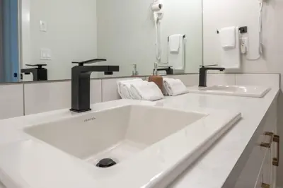 a white bathroom with a sink and a mirror at The Promenade I Patio and BBQ I Fire pit I Sleep 9 in Sylvan Lake