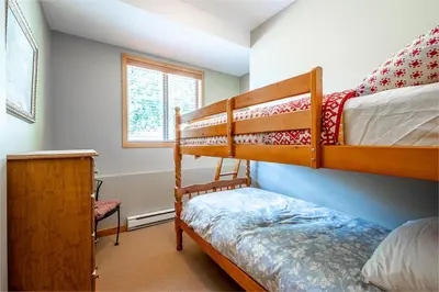a bedroom with two bunk beds and a window at Bear's Paw Chalet - Amazing Location & Ski In-Out in Big White
