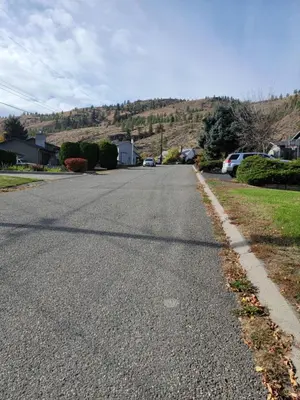an empty street with cars parked on the side of the road at Charming - 2 bedrooms suite, 1 full bath & family room in Kamloops