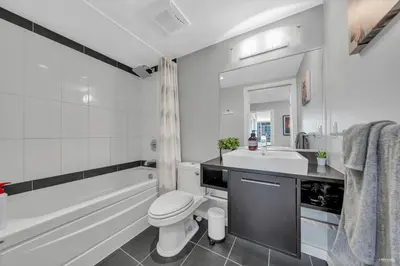 a bathroom with a tub and a toilet and a sink at Spacious DT 2-BDR High-rise with view, pool, gym in Vancouver