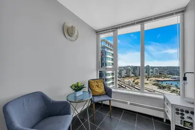 a living room with two chairs and a large window at Spacious DT 2-BDR High-rise with view, pool, gym in Vancouver