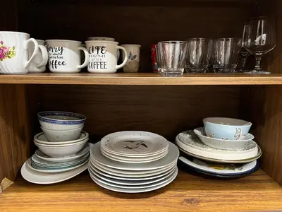 a wooden shelf with plates and cups and dishes at Licensed spacious basement suite with one king-size bed in Chilliwack