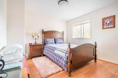 a bedroom with a bed and a dresser and a window at Steveston Village Bed and Breakfast in Richmond