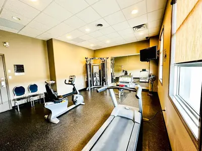 a gym with treadmills and machines in a room at Beaverlodge Motor Inn in Beaverlodge